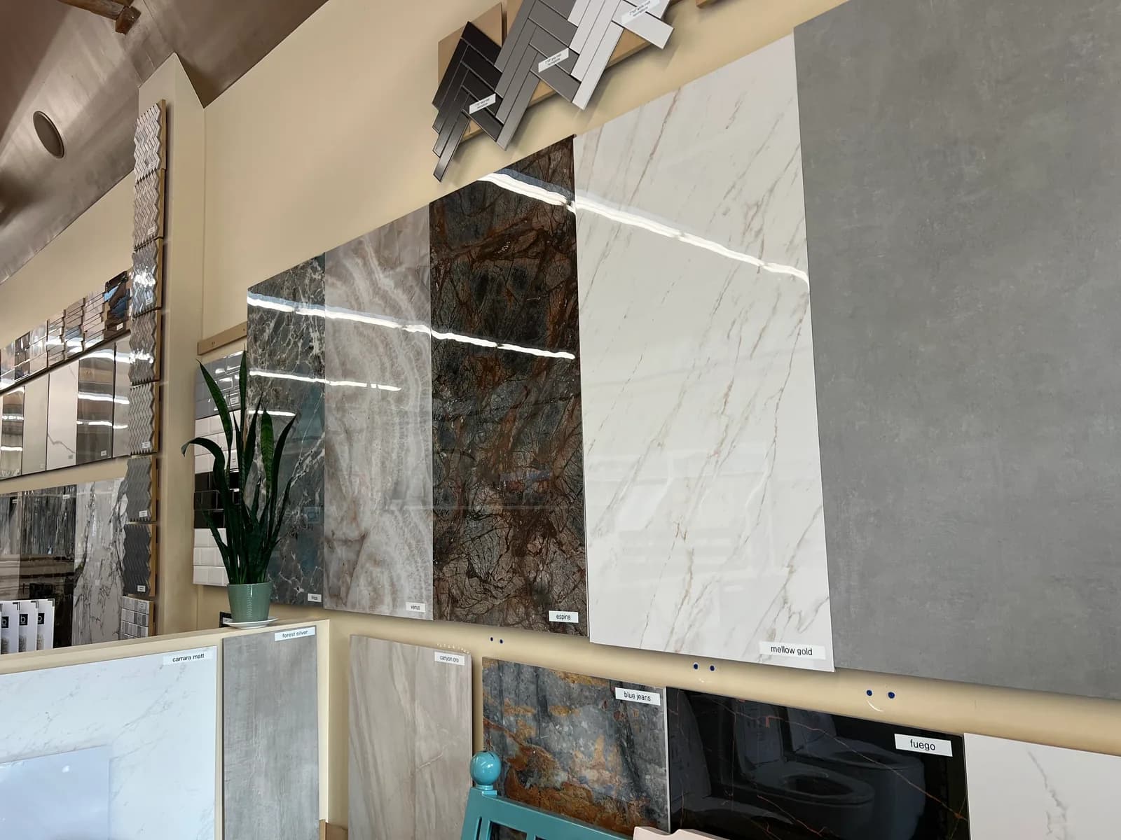 Large-format porcelain tiles in marble and stone finishes, mounted on the showroom wall.