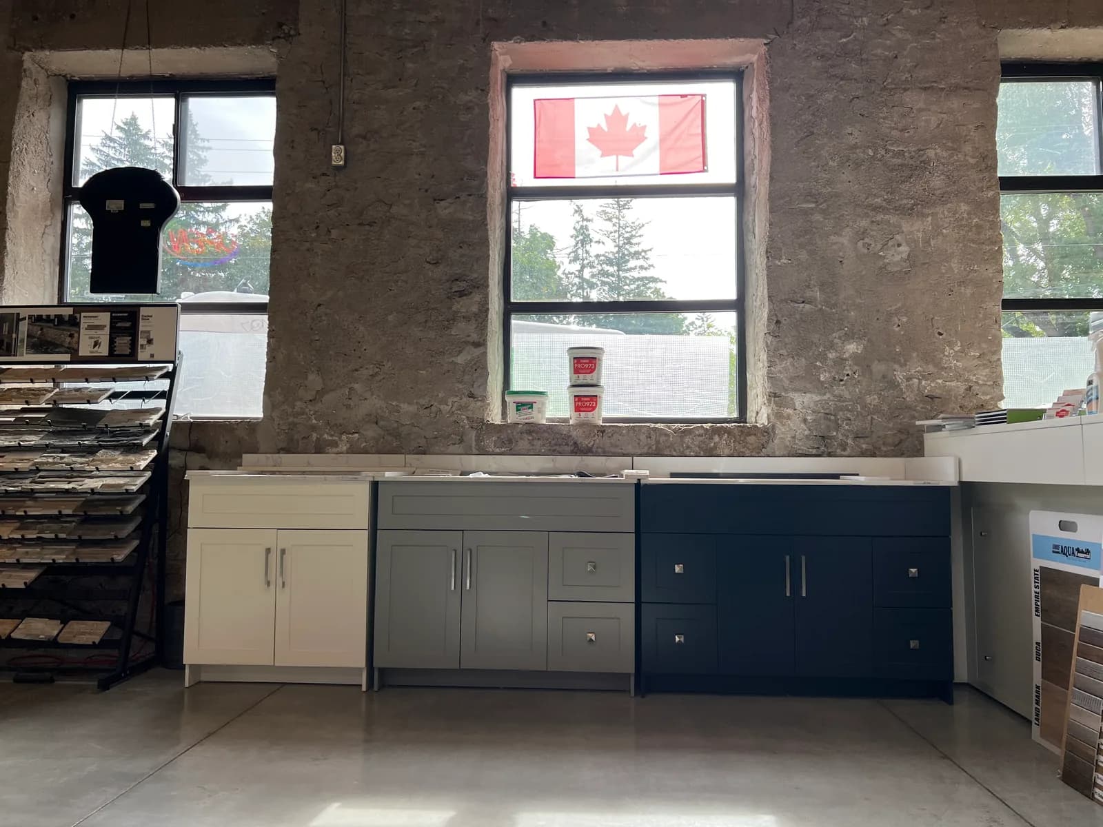 Vanity units on display beneath the showroom's original limestone wall and tall windows.