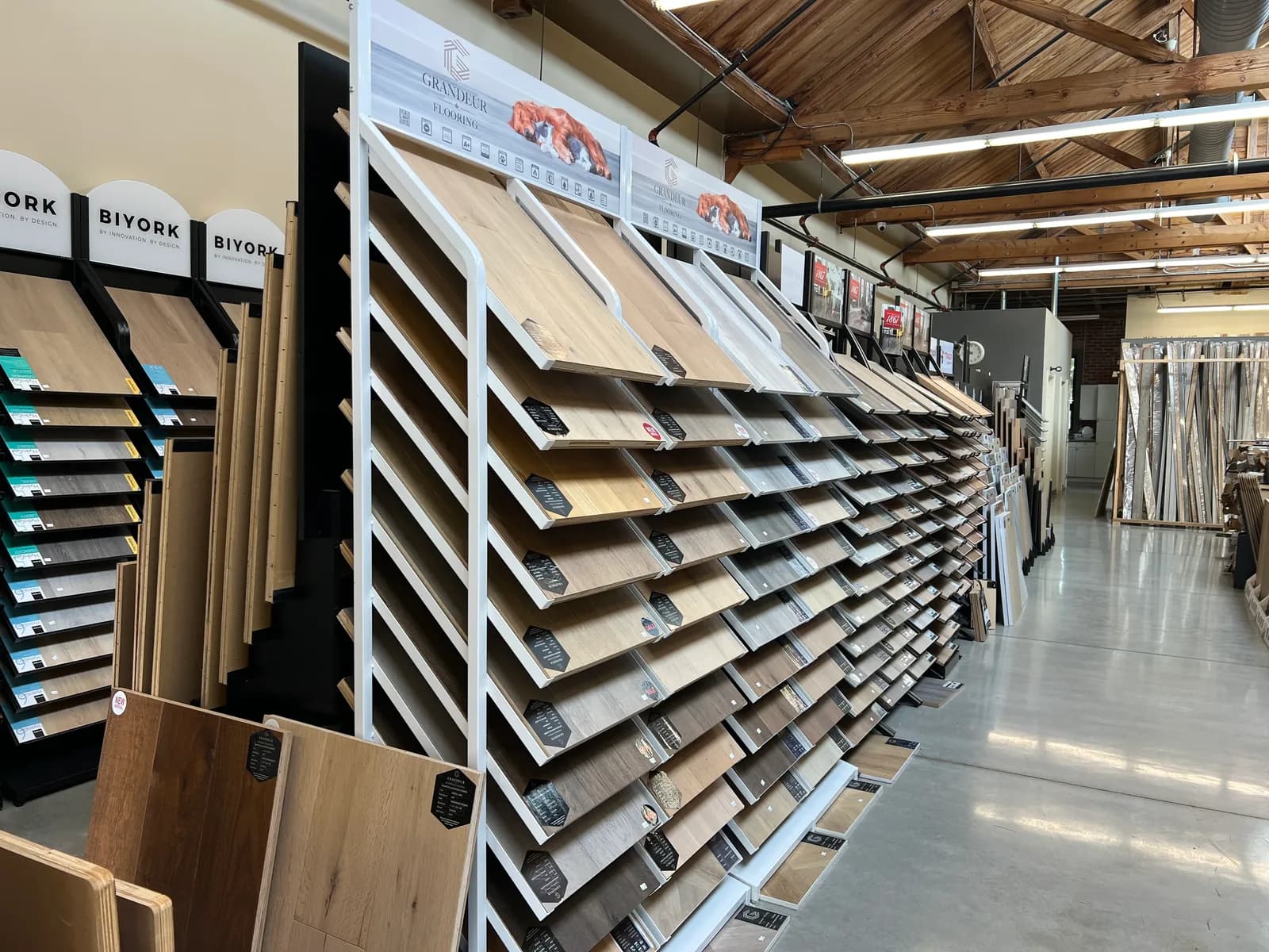 A long rack of luxury vinyl plank samples in pale and mid-brown tones.