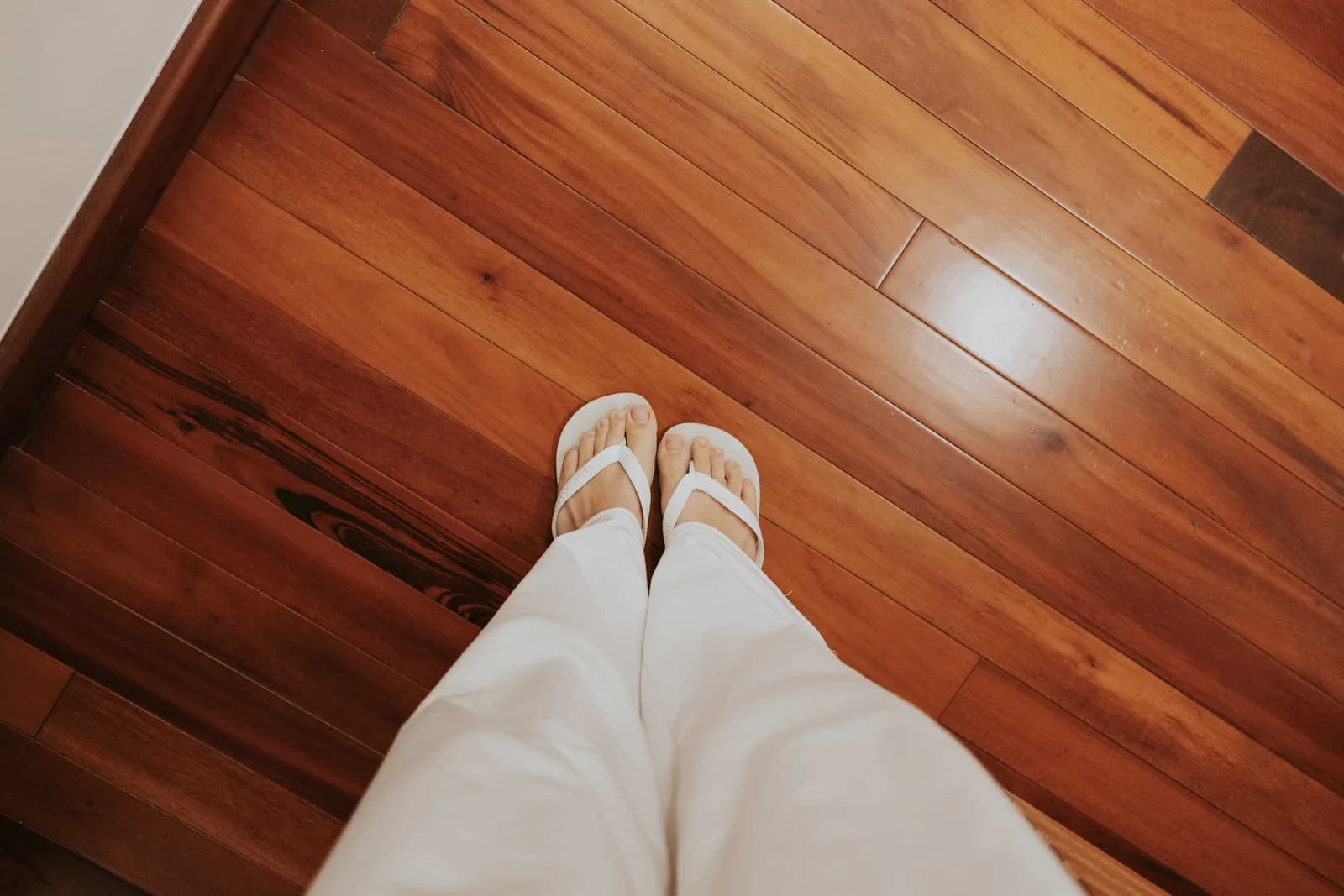 An oak hardwood floor, brightly lit, with someone standing on top looking down.